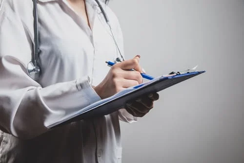 врач записывает план лечения после детоксикации от алкоголя